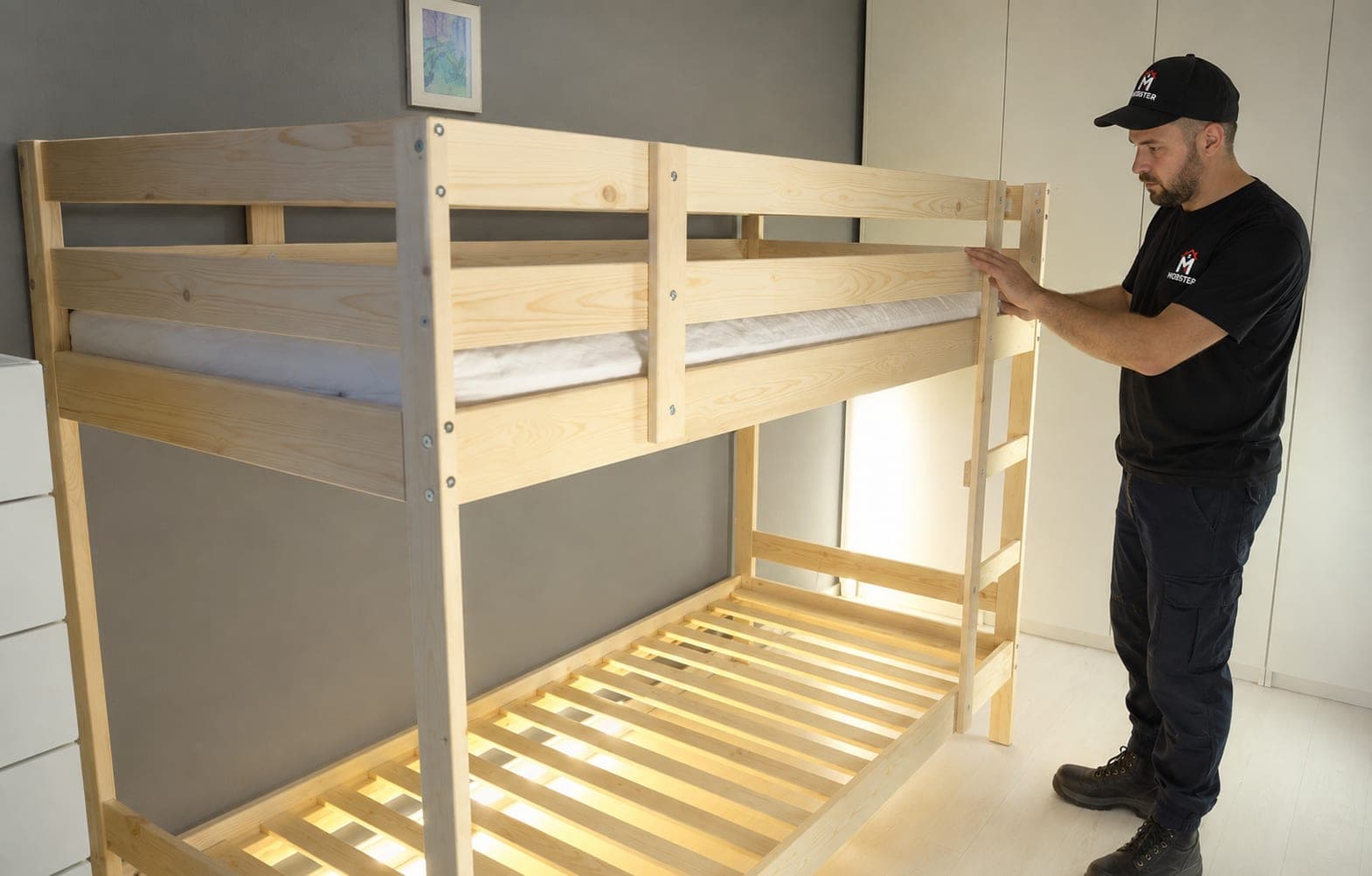 A Mobster fitting the ladder to a newly assembled bunk bed