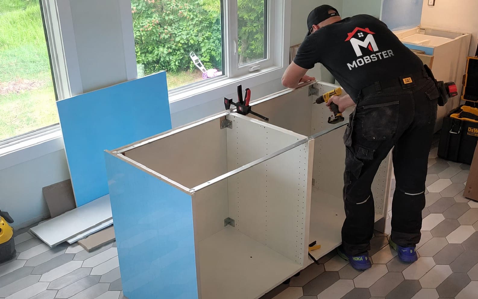 A Mobster clamping and drilling a kitchen base cabinet together